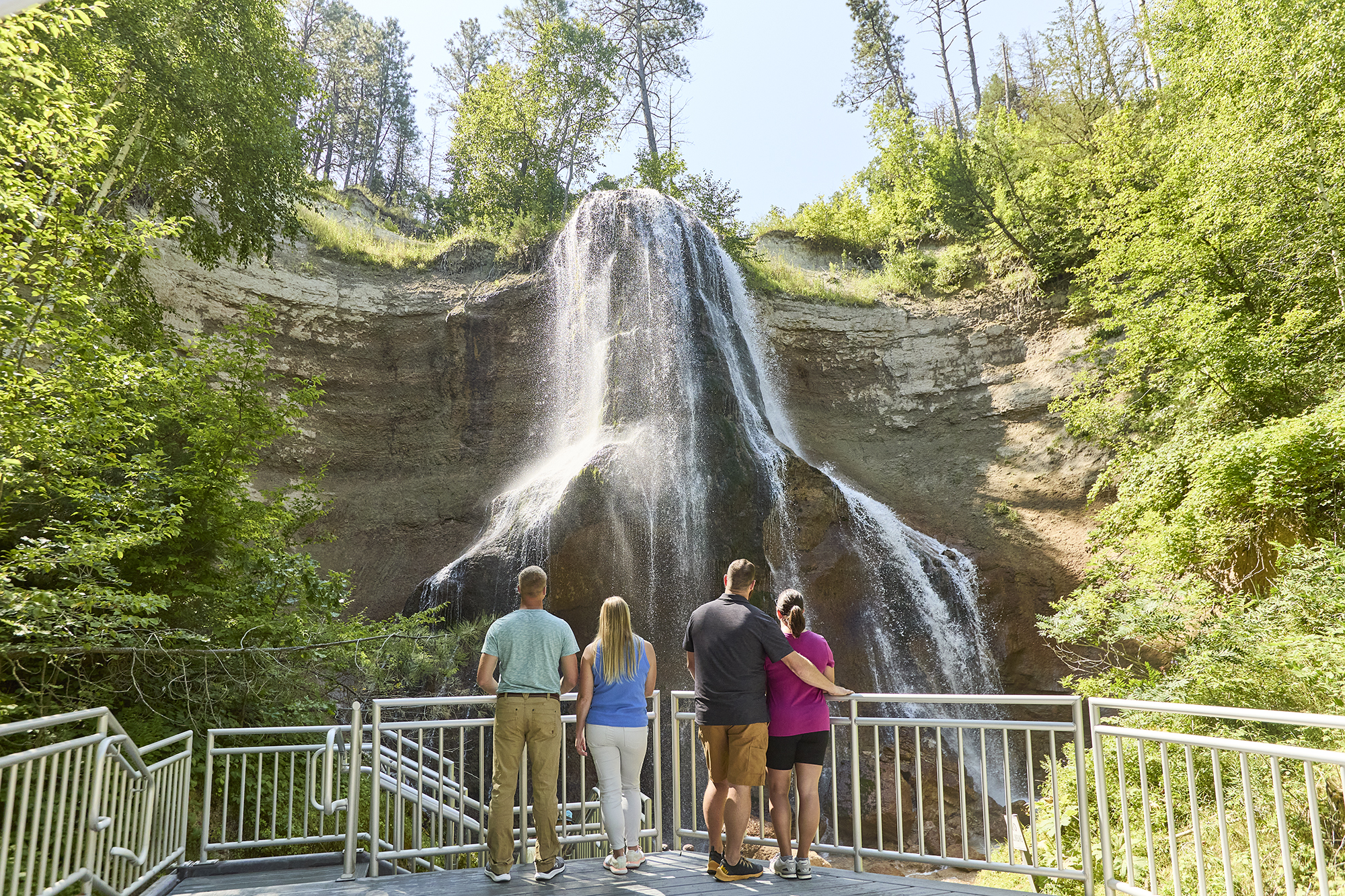 A group of four looking at Smith Falls from a viewing area.