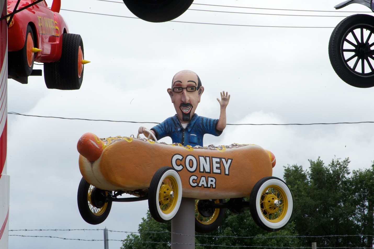 The Coney Car cartoon car with a replica of George driving it, suspended in the air at Fred's Flying Circus.