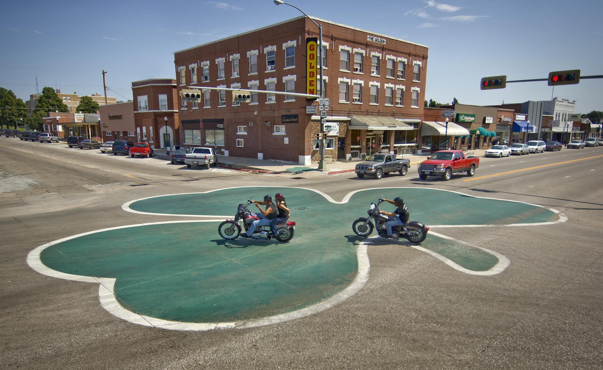 Motorcyclists riding over the world's largest shamrock road painting in O'Neill.