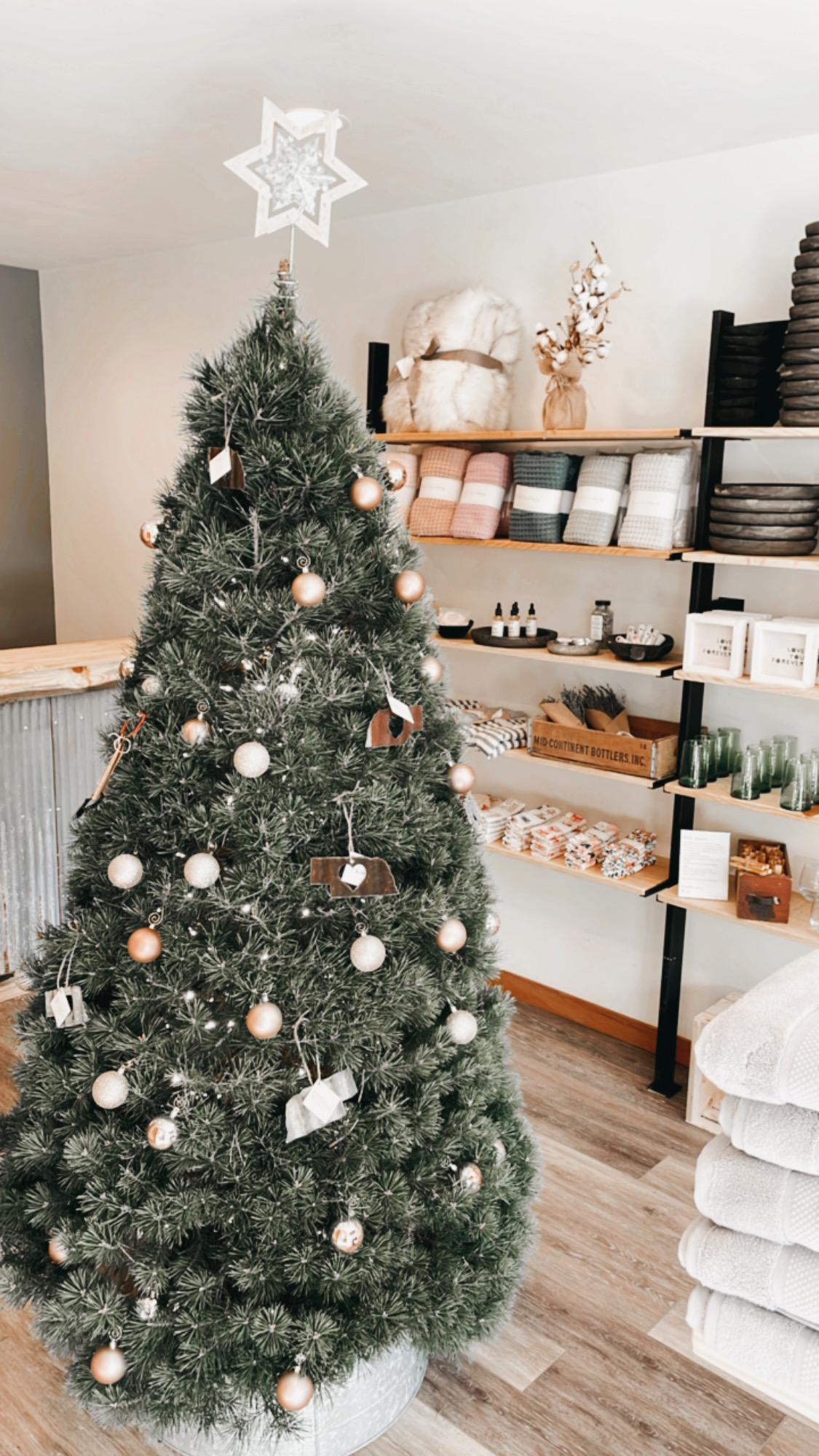 A Christmas tree and goods inside Rustic Riverside Mercantile.