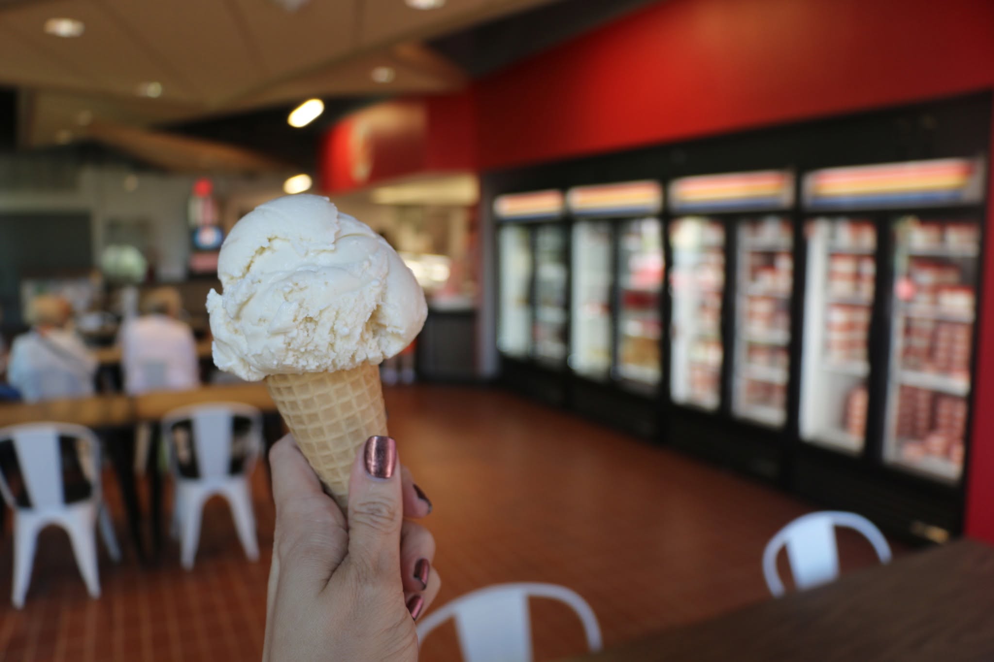 A close up of an ice cream cone with a large scoop of white ice cream at UNL Dairy Store.