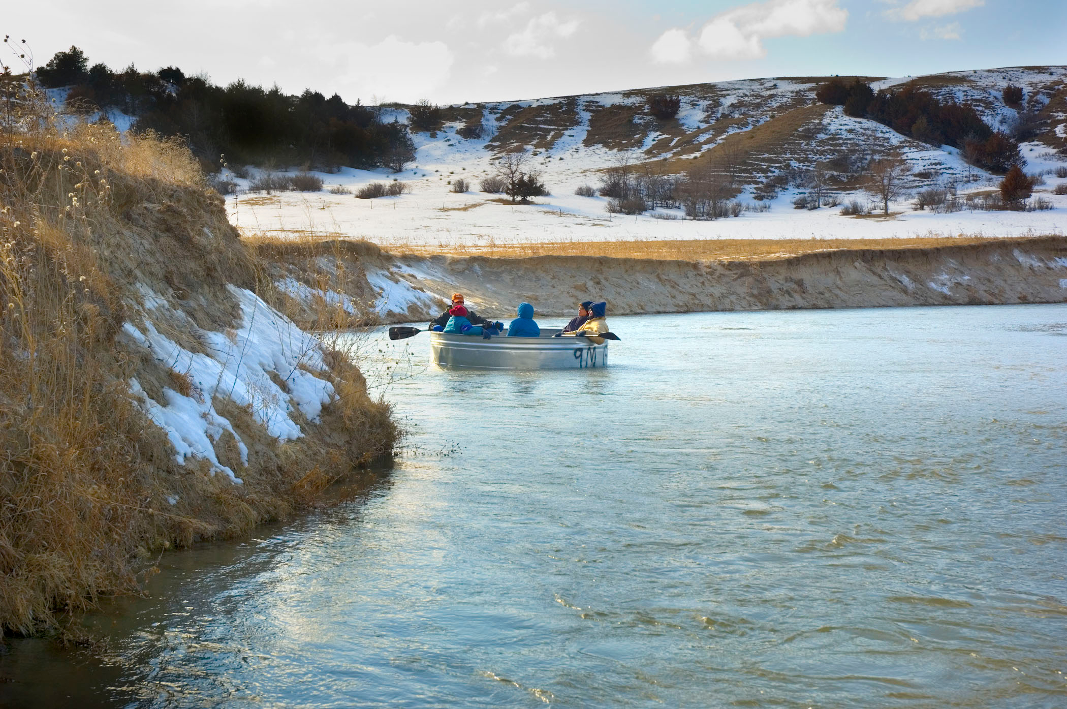 A group tanking on a river in winter surrounded by snowy landscapes in Mullen.