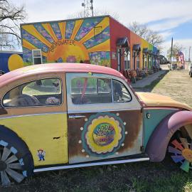 Classic car and colorful outside view of Lazy U Roadside Market.