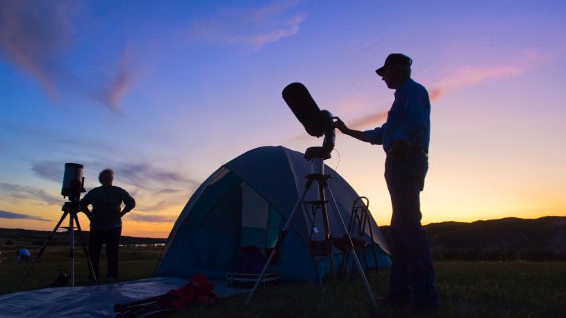 Folks setting up telescopes and tents at dusk for the Nebraska Star Party.